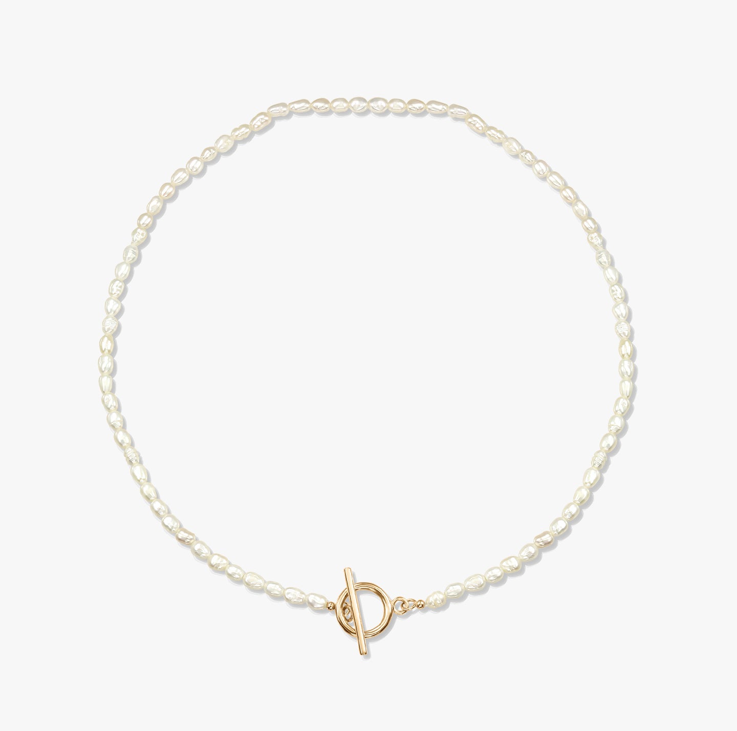Collana minimalista con perla e chiusura a T in oro su sfondo bianco.