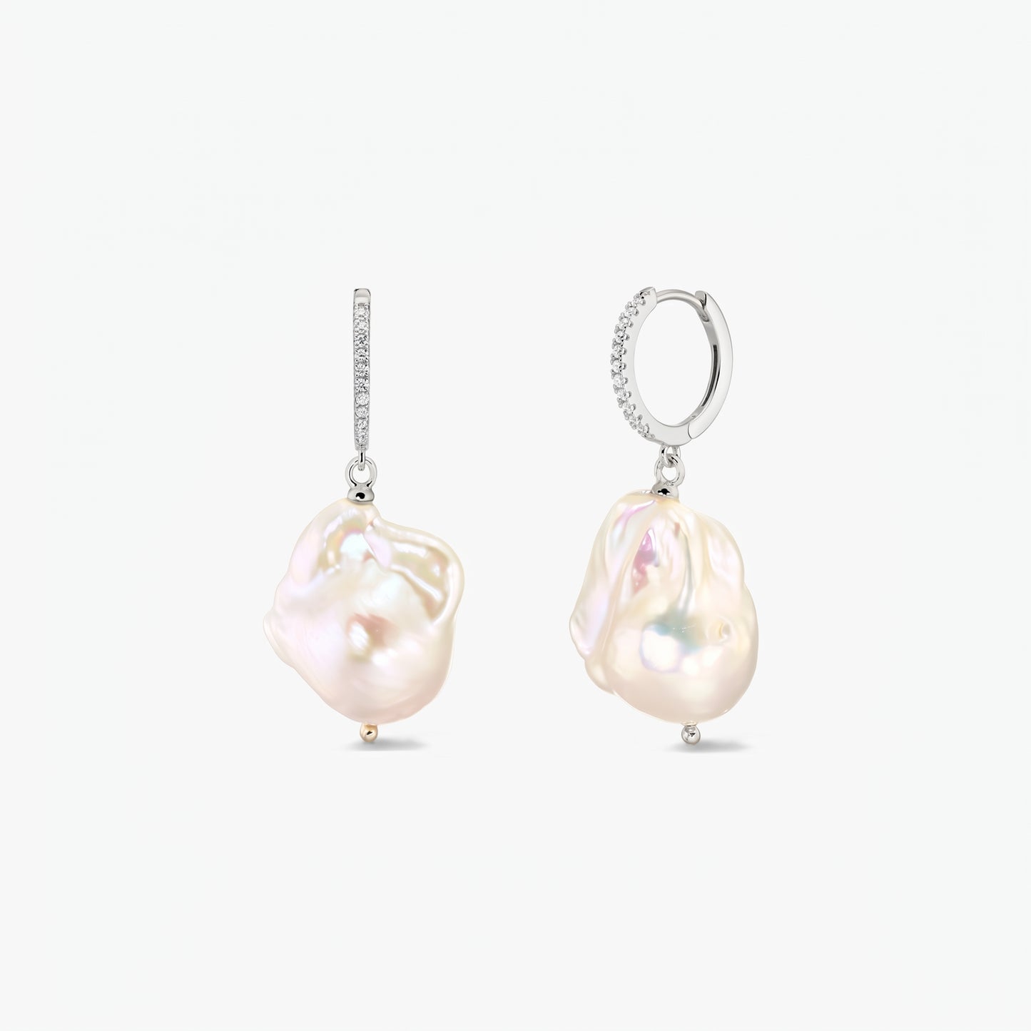 Coppia di orecchini a cerchio in argento 925 rodiato con pavé di zirconia e grandi perle barocche organiche su sfondo bianco.