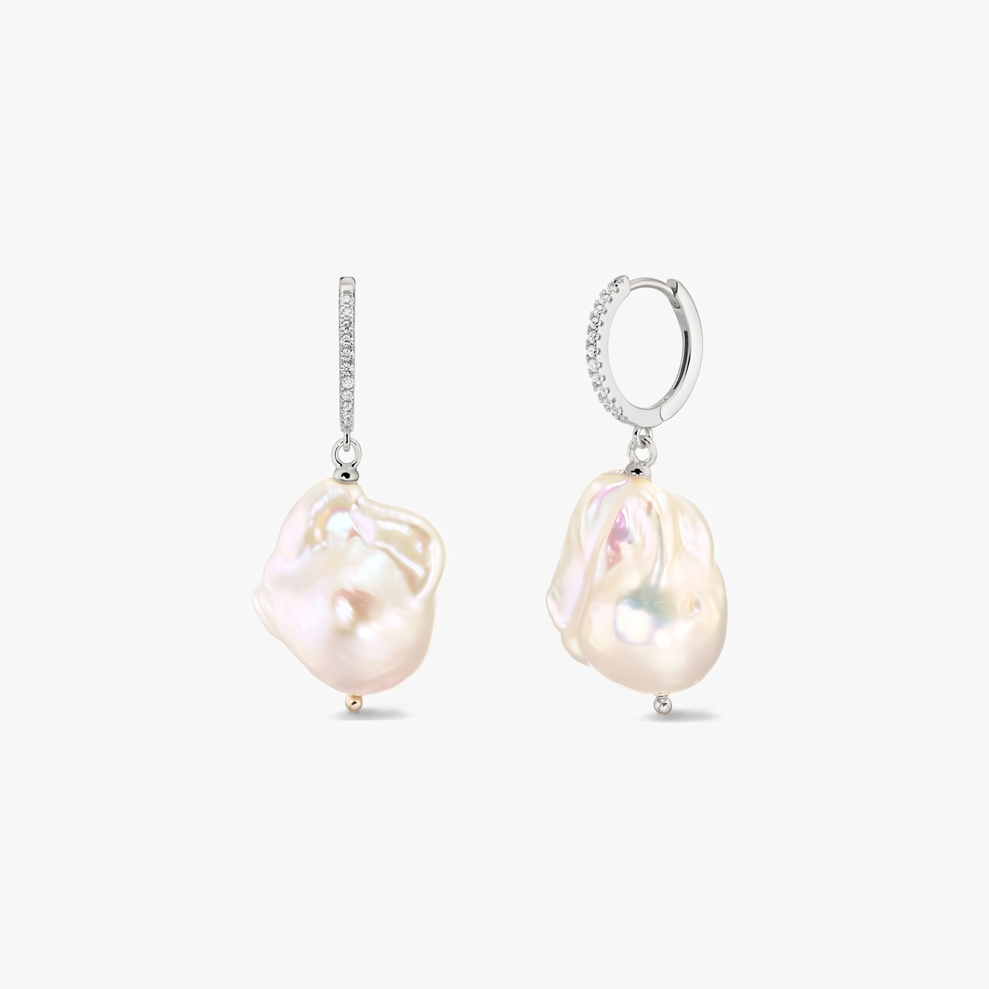 Coppia di orecchini a cerchio in argento 925 rodiato con pavé di zirconia e grandi perle barocche organiche su sfondo bianco.