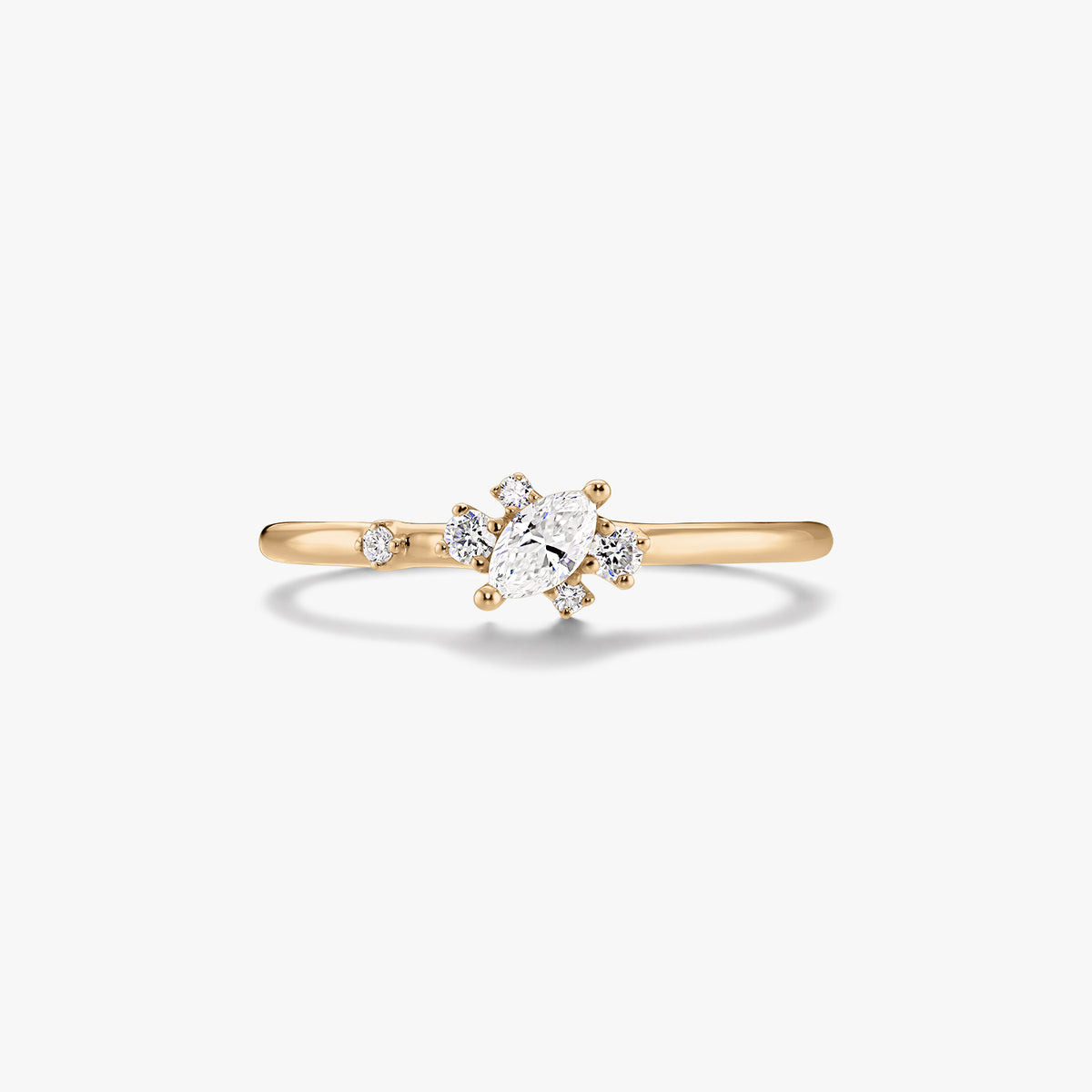 Anello sottile in oro giallo 14K con diamante centrale taglio marquise e piccoli diamanti rotondi d'accento su sfondo bianco.