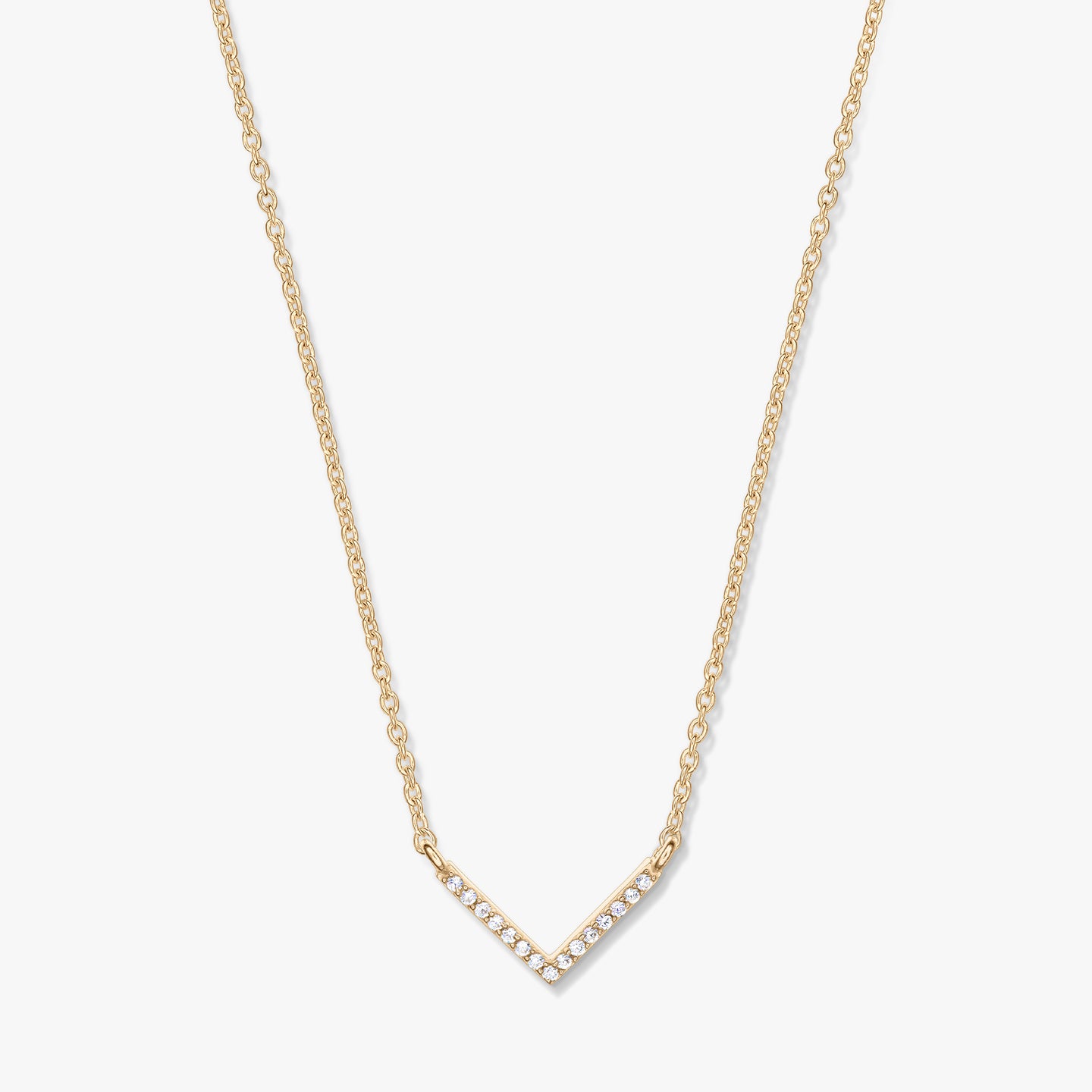 Collana dorata con pendente a forma di V tempestato di zirconi su catena delicata, fotografata su sfondo bianco.