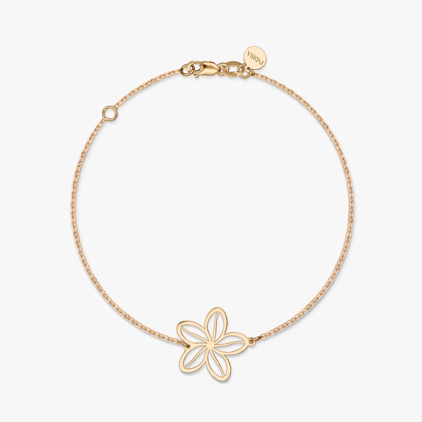 Un braccialetto minimalista in oro con un delicato ciondolo a forma di fiore su uno sfondo bianco solido.