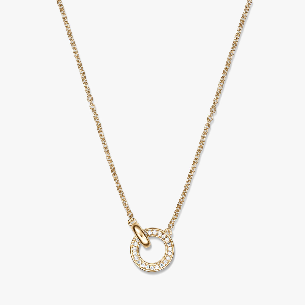 Collana in argento con maglie dorate e piccolo pendente a cerchio aperto in tonalità oro, incastonato a pavé con pietre trasparenti, su una catenina fine, mostrata su sfondo bianco.