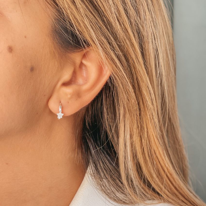 Vista ravvicinata di un orecchino in argento con zirconi a forma di stella