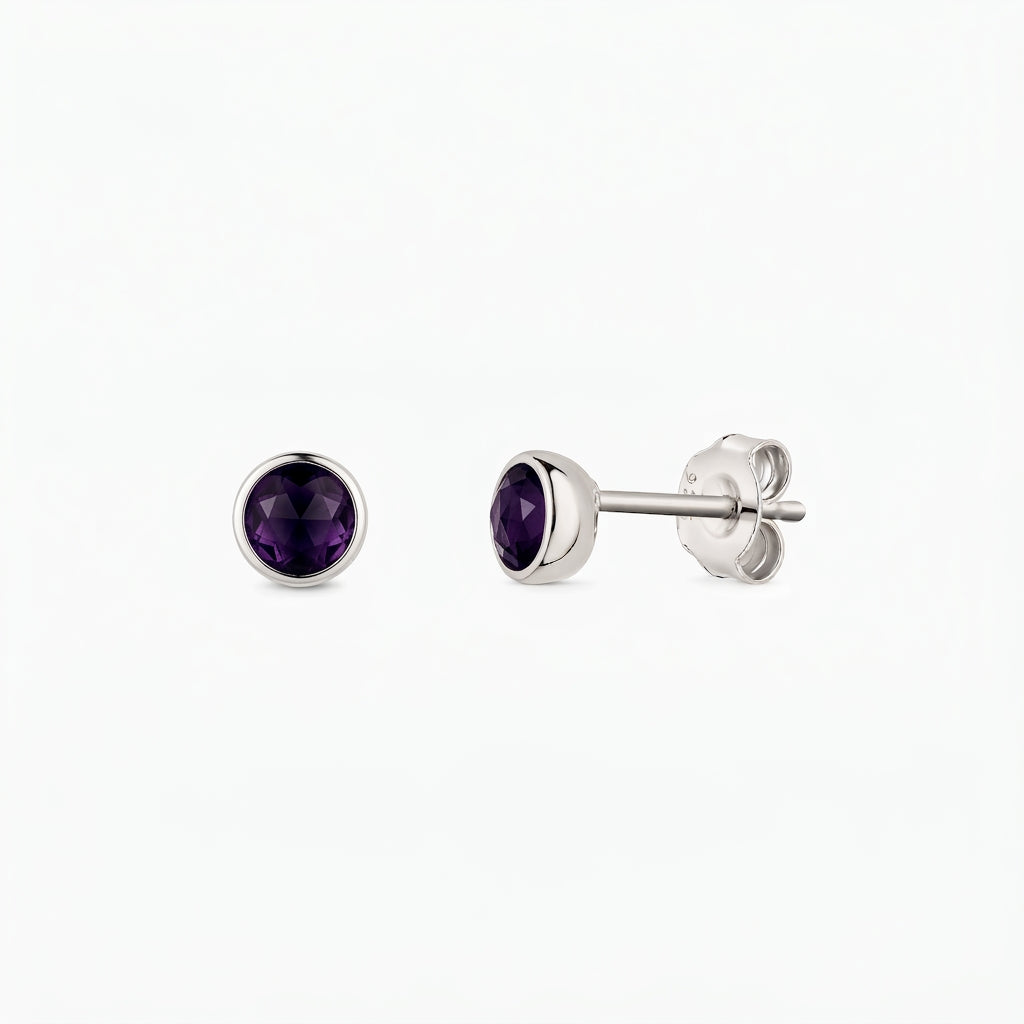 Paio di orecchini a perno in argento 925 con pietre di ametista rotonde sfaccettate, incastonate a castone, mostrati frontalmente e di lato su sfondo bianco.