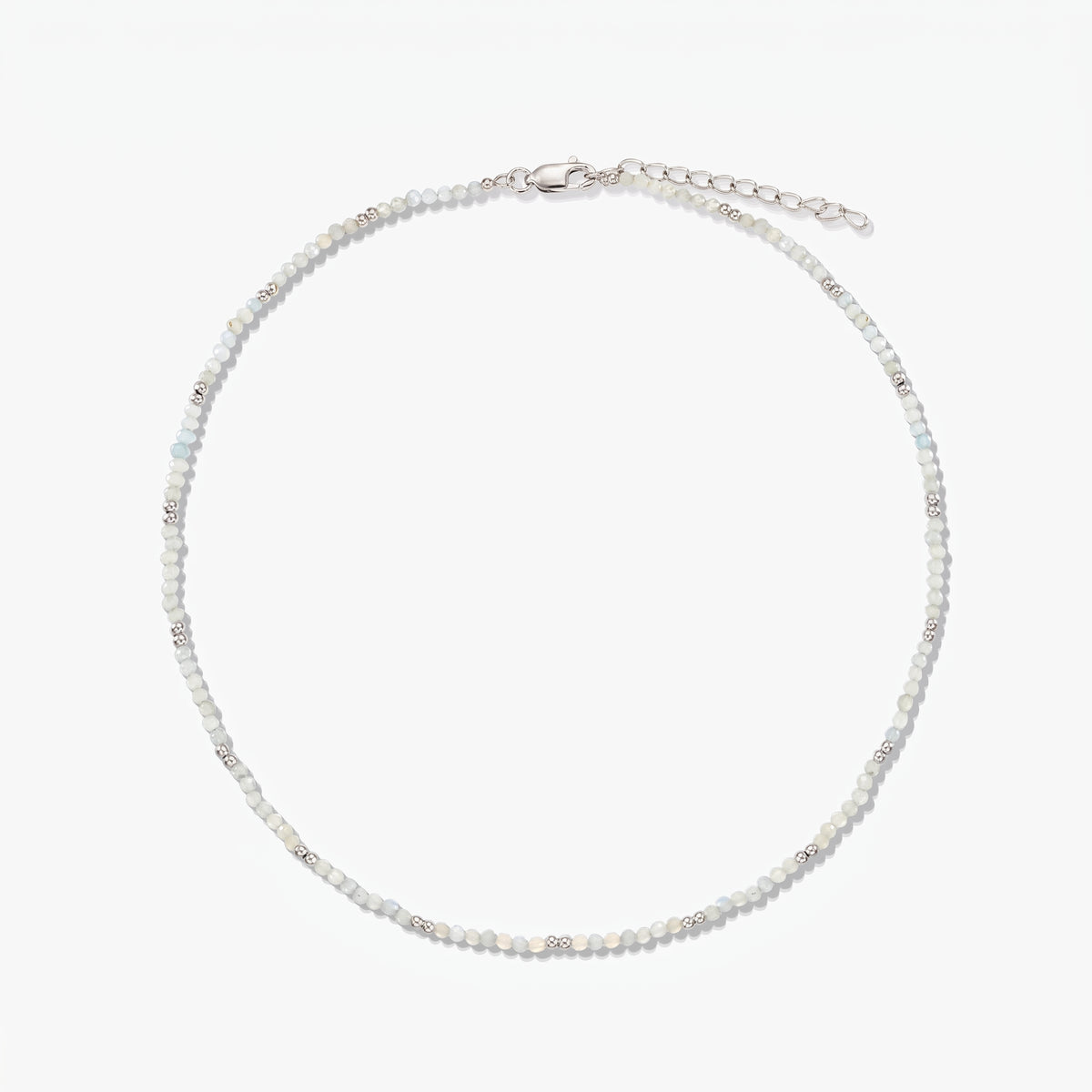 Collana in argento sterling delicata con piccole perline di pietra di luna e catena di prolunga regolabile, fotografata su sfondo bianco.