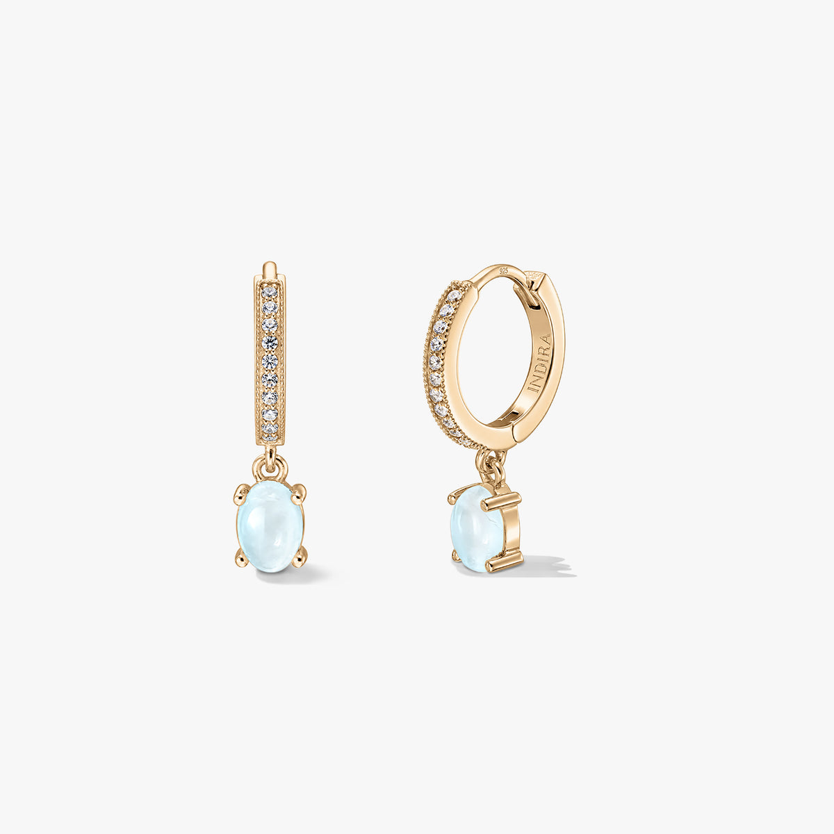 Orecchini Indira Golden Gem Huggies in argento con gocce di pietra di luna ovale e cerchi con pavé, mostrati su sfondo bianco nelle viste frontale e laterale.