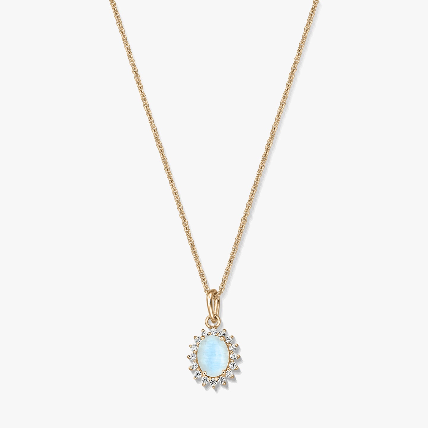 Collana in argento sterling placcato oro con un pendente ovale in pietra di luna azzurro chiaro, incorniciato da piccole pietre trasparenti, su sfondo bianco.
