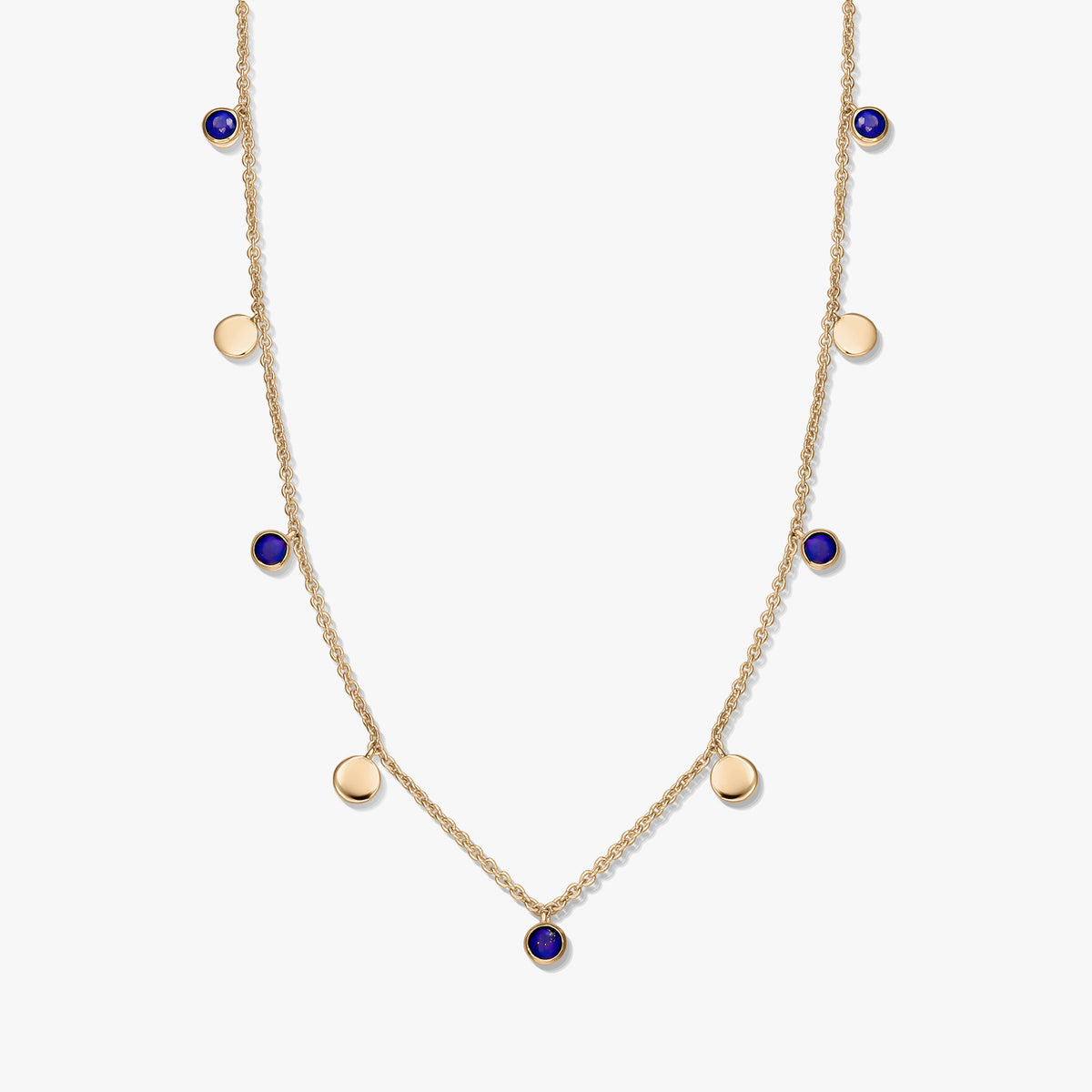 Collana a stazioni in argento 925 placcato oro con cabochon rotondi in lapislazzuli e piccoli ciondoli a disco dorati su una catena delicata, fotografata su sfondo bianco.
