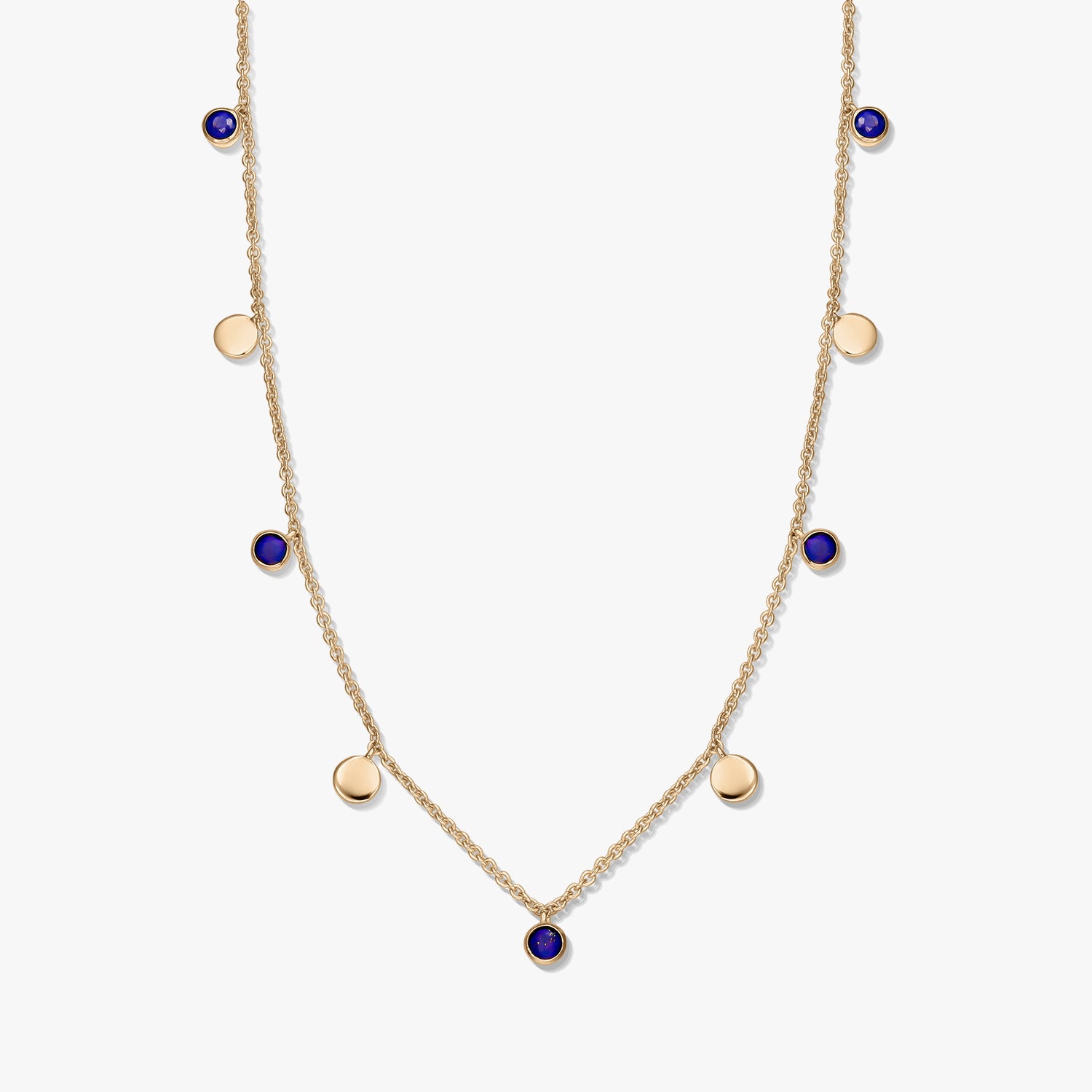 Collana a stazioni in argento 925 placcato oro con cabochon rotondi in lapislazzuli e piccoli ciondoli a disco dorati su una catena delicata, fotografata su sfondo bianco.