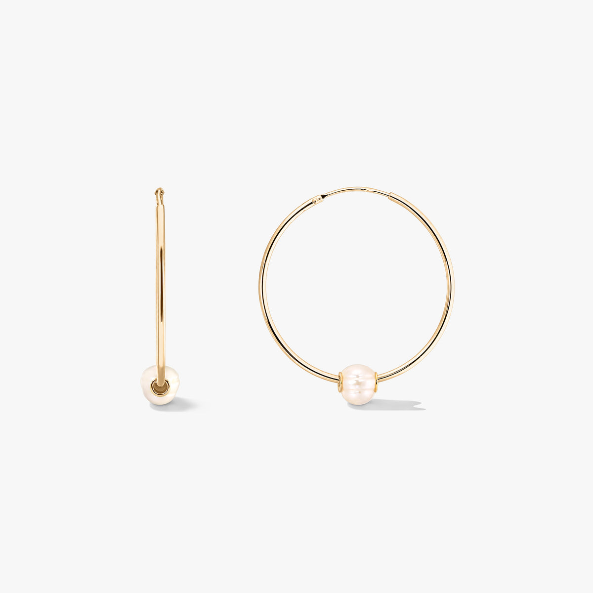 Orecchini a cerchio in argento Golden Ines con perle coltivate, mostrati davanti e di lato su sfondo bianco.