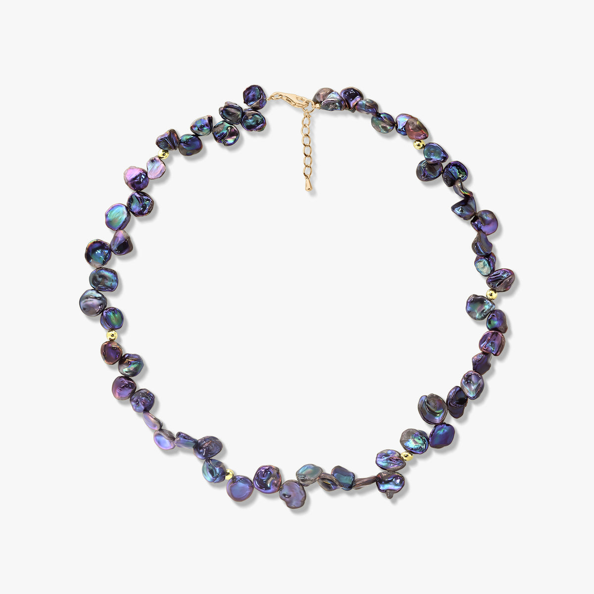 Collana di perle keshi nere iridescenti con piccoli accenti in oro e catena di prolunga regolabile, fotografata su sfondo bianco.