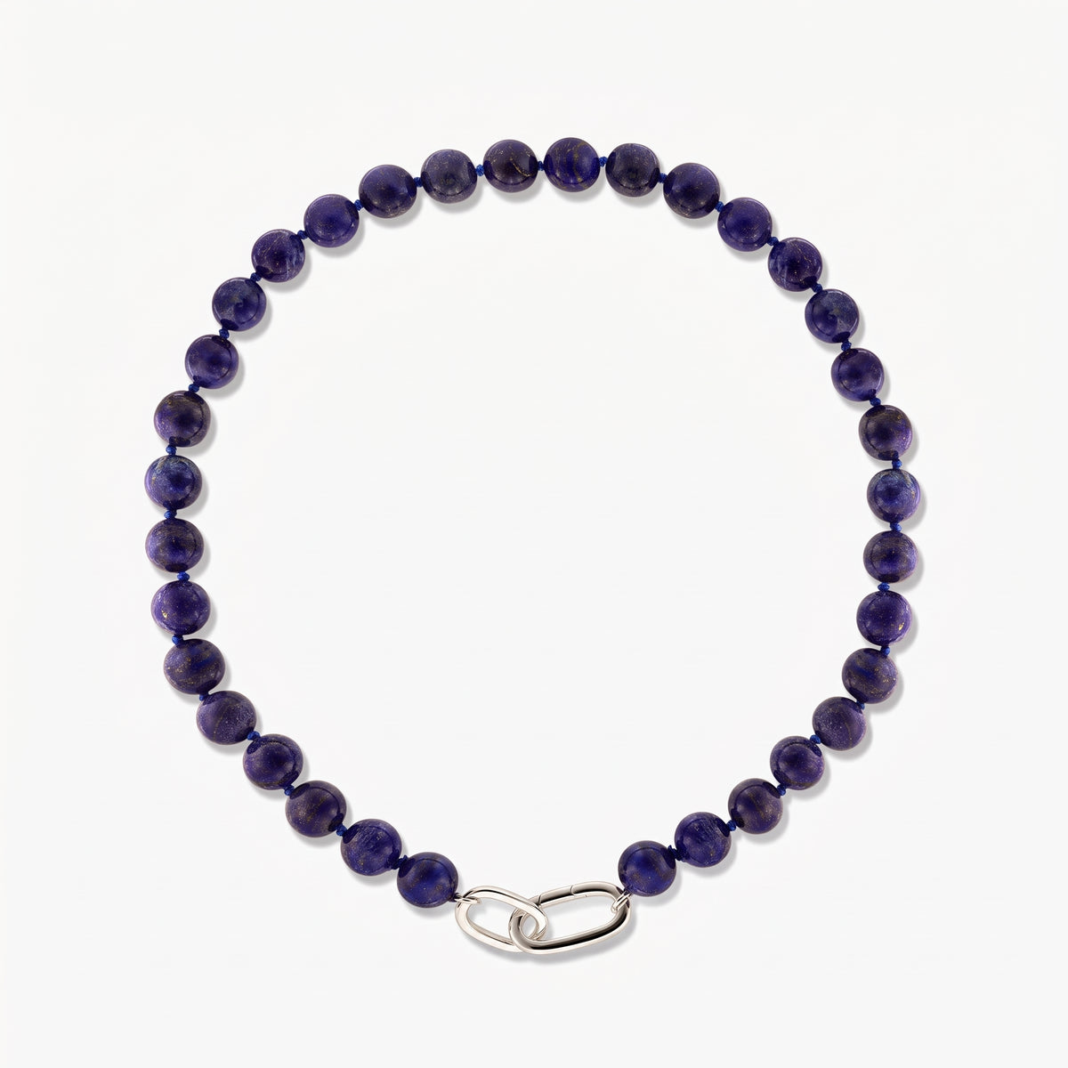 Foto quadrata in studio della collana Mareille in argento con perle rotonde di lapislazzuli e chiusura a maglia liscia in argento su sfondo bianco.