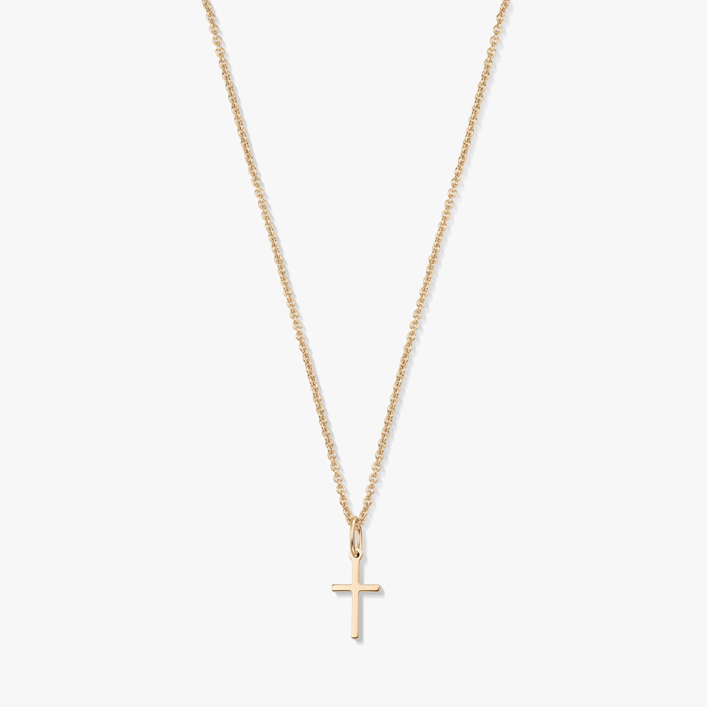 Collana minimalista in oro giallo 14K con un piccolo pendente a forma di croce su una catena fine, isolata su sfondo bianco.