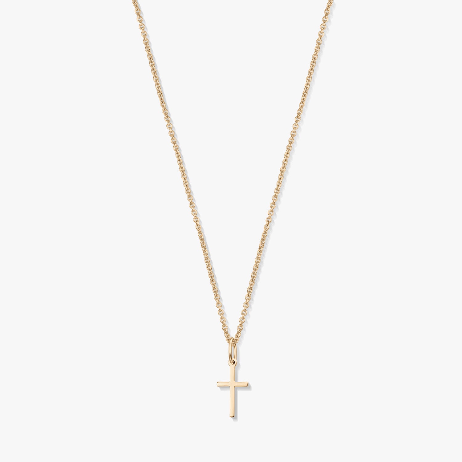 Collana minimalista in oro giallo 14K con un piccolo pendente a forma di croce su una catena fine, isolata su sfondo bianco.