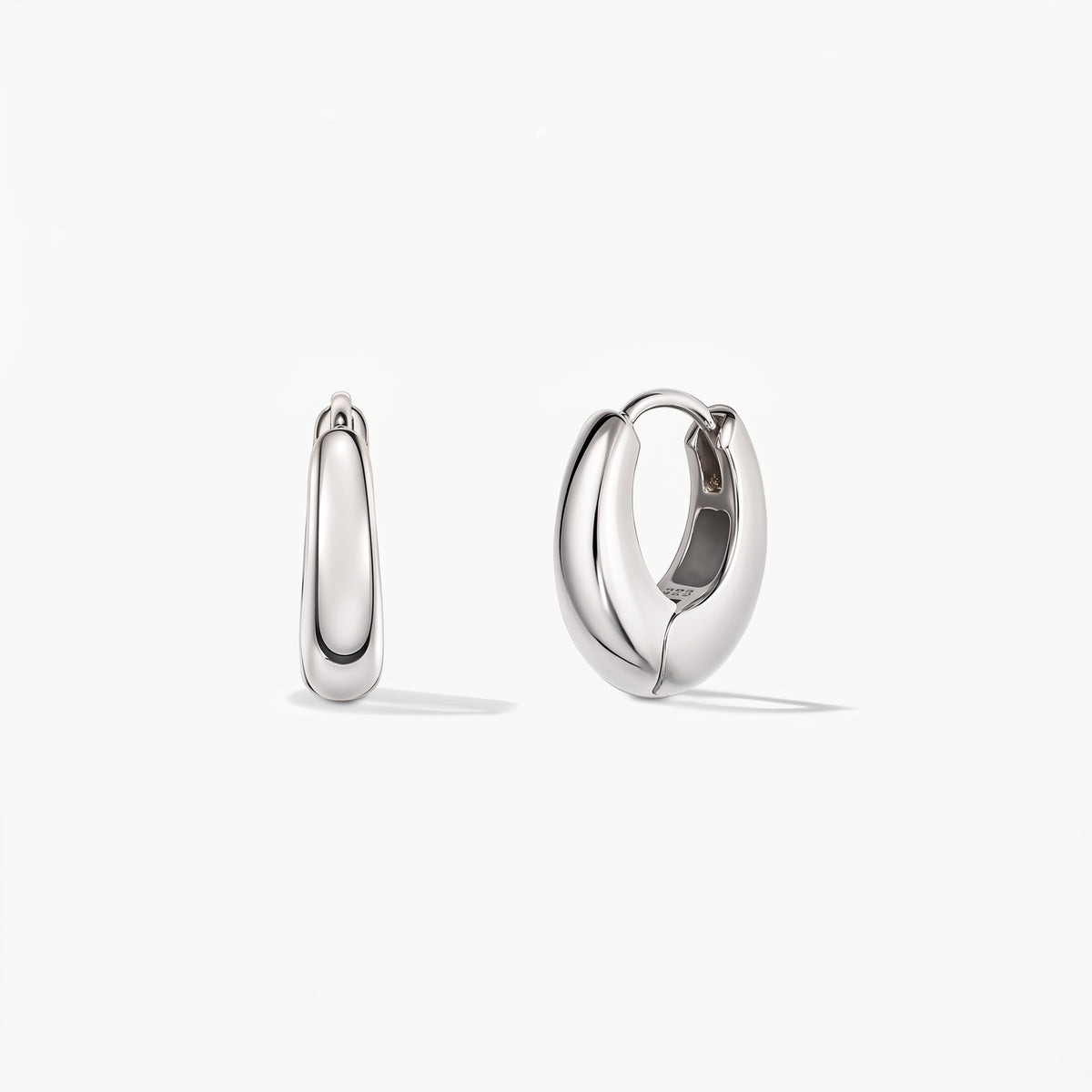 Coppia di orecchini huggie a cerchio in argento, mini dome lucidi, su sfondo bianco, in vista frontale; uno è aperto per mostrare la chiusura a cerniera.