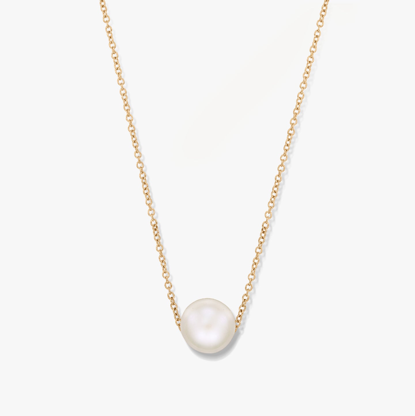 Collana in oro con un ciondolo di perla singola su sfondo bianco.