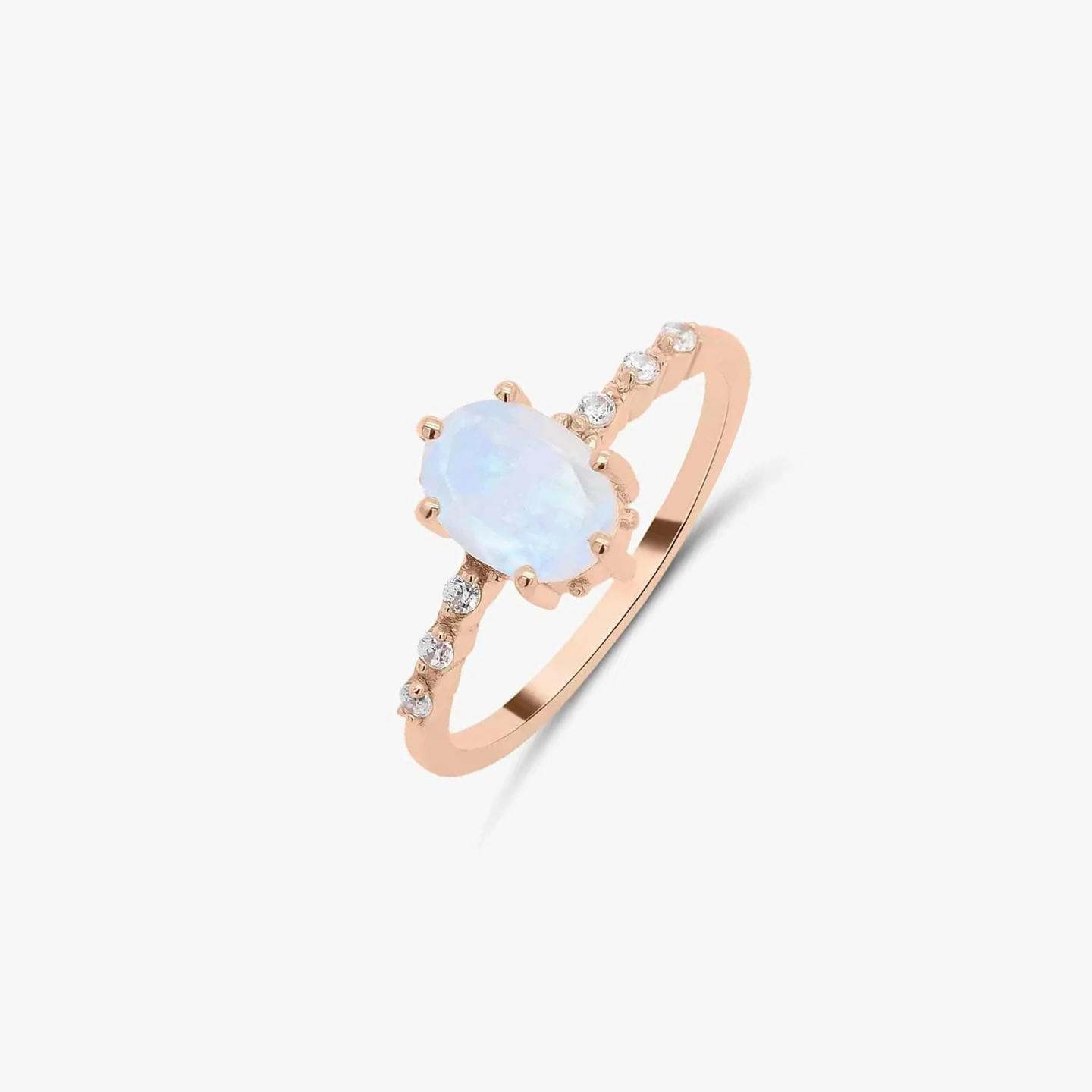 Anello in oro rosa con pietra di luna e zirconi su sfondo bianco.