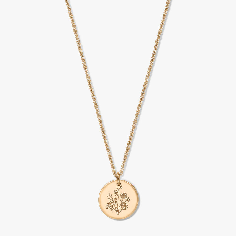 Collana in argento placcato oro con sottile catena a corda e ciondolo tondo a moneta inciso con un aster, fiore di nascita, isolata su sfondo bianco.
