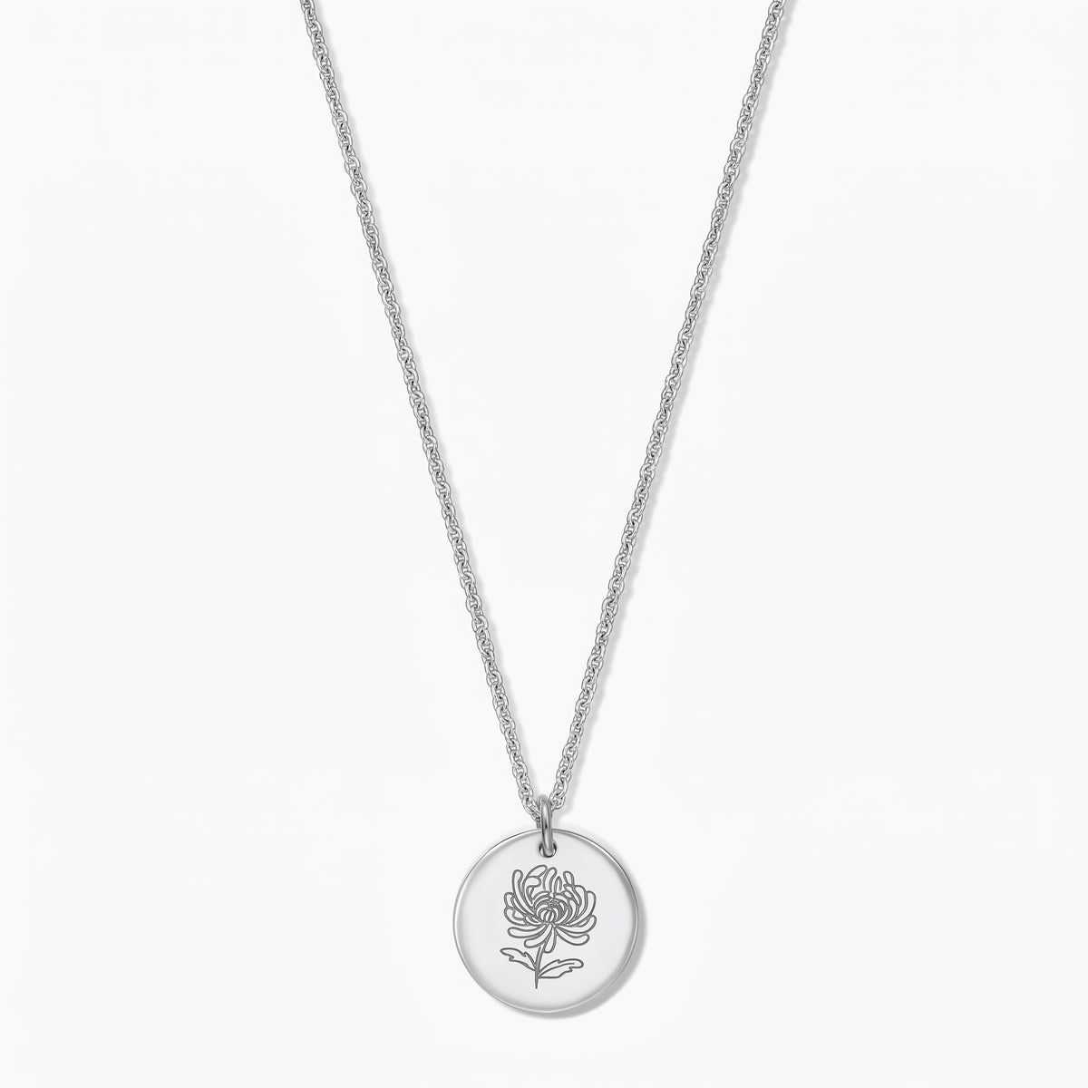 Collana in argento sterling con fiore del mese di nascita, ciondolo a disco rotondo inciso con un crisantemo su catenina sottile, fotografata su sfondo bianco.