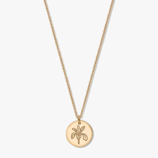 Collana con fiore del mese di nascita in finitura dorata, con pendente rotondo inciso con il fiore dell'iris su catenina delicata, isolata su sfondo bianco.