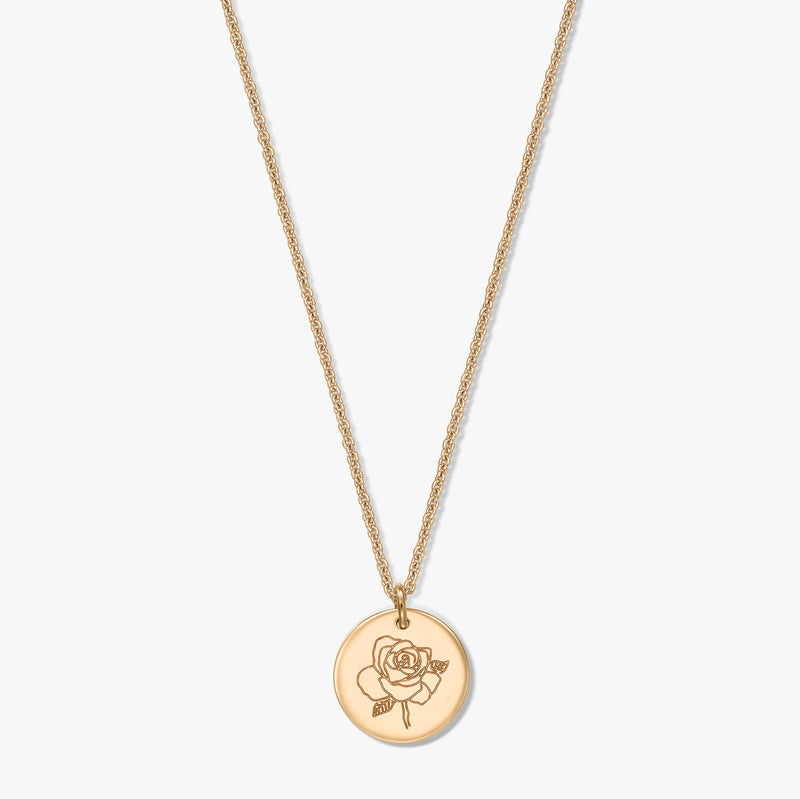 Collana in argento placcata in oro con medaglione rotondo inciso con una rosa, fotografata al centro su sfondo bianco.