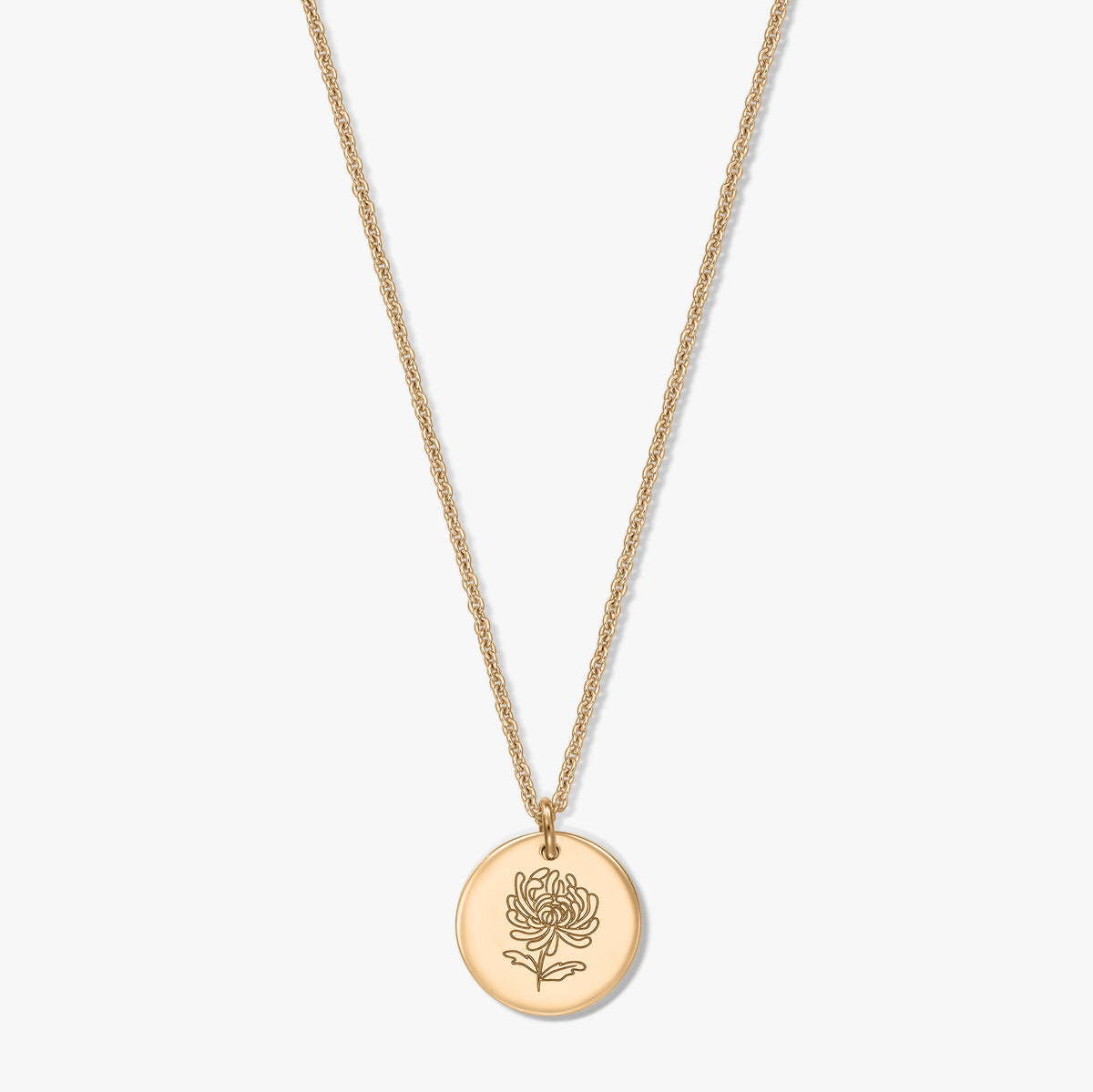Collana in argento placcato oro con ciondolo tondo a forma di moneta inciso con un crisantemo, fiore del mese di novembre, su sfondo bianco.
