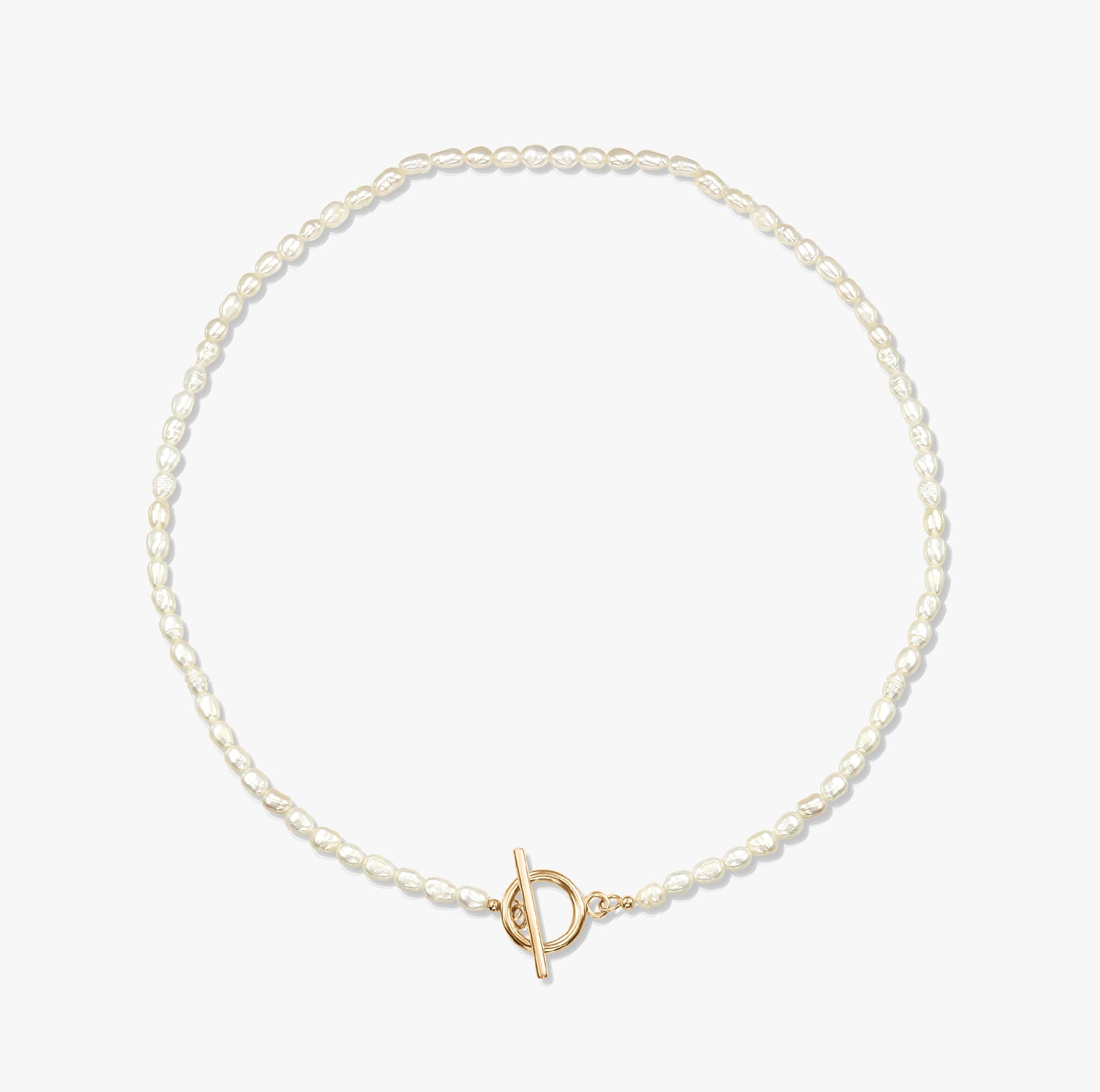 Collana minimalista con perla e chiusura a T in oro su sfondo bianco.