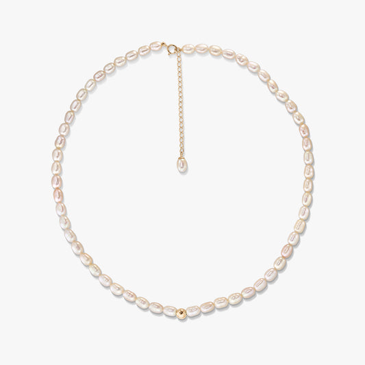 Collana Blair in oro con perle ovali naturali disposte in cerchio su sfondo bianco, con chiusura in oro 14K, catenella di prolunga e piccola perlina decorativa in oro.