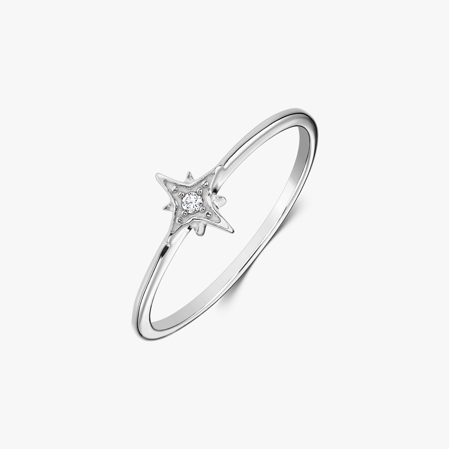 Anello delicato in argento sterling con montatura a forma di stella che incastona una zirconia bianca, fotografato su sfondo bianco.