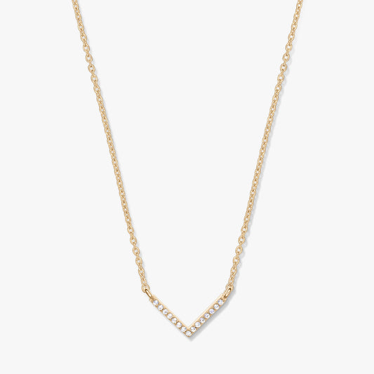 Collana dorata con pendente a forma di V tempestato di zirconi su catena delicata, fotografata su sfondo bianco.
