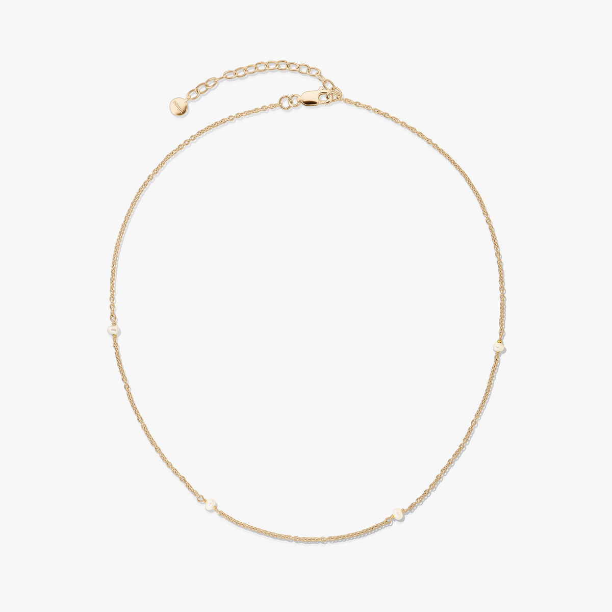 Collana in argento 925 placcata in oro, delicata, con piccole perle naturali e prolunga regolabile con chiusura a moschettone su sfondo bianco.
