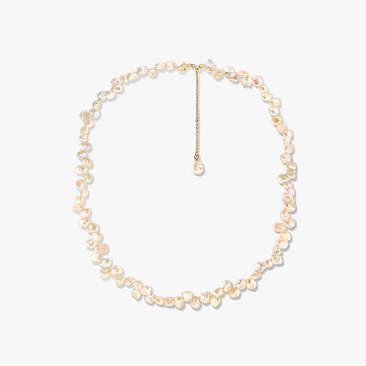 Collana in argento placcato oro con perle keshi rosa irregolari e prolunga regolabile, fotografata su sfondo bianco.