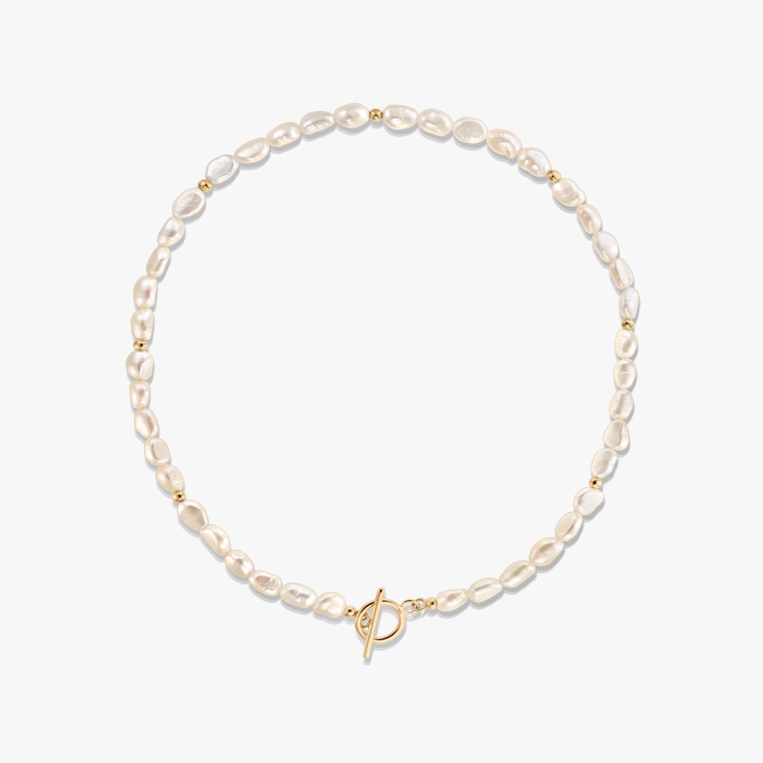 Foto in studio di una collana di perle naturali con piccole perline distanziatrici dorate e chiusura a T in tonalità oro, disposta a cerchio su sfondo bianco.