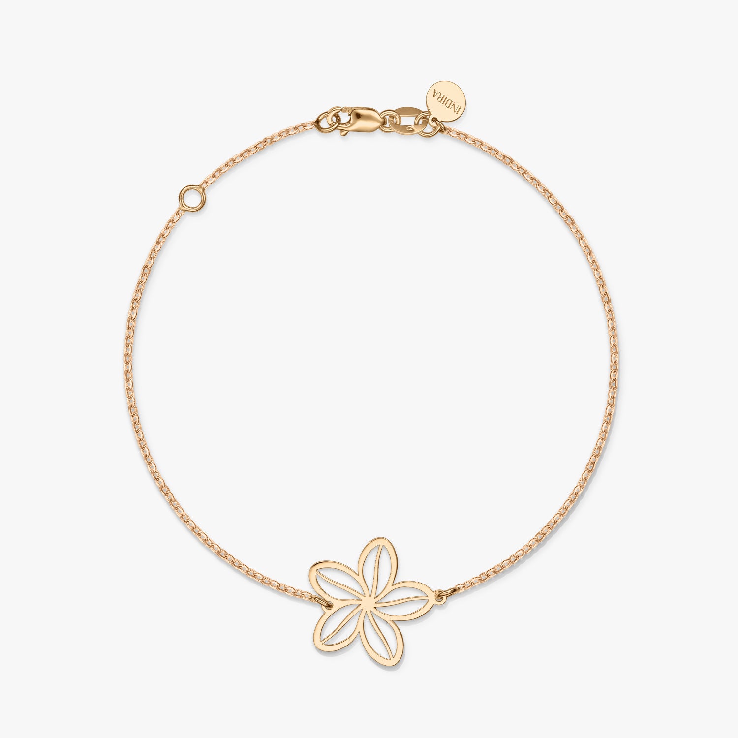Un braccialetto minimalista in oro con un delicato ciondolo a forma di fiore su uno sfondo bianco solido.