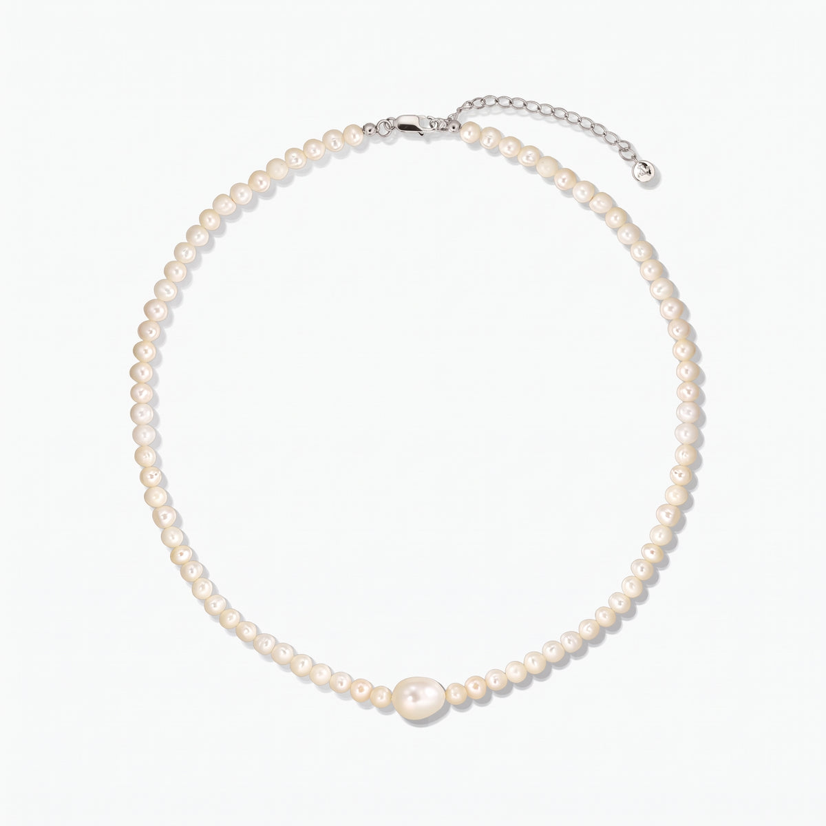 Collana di perle coltivate con una perla centrale più grande e chiusura in argento con prolunga, fotografata su sfondo bianco.