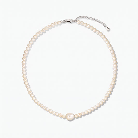 Collana di perle coltivate con una perla centrale più grande e chiusura in argento con prolunga, fotografata su sfondo bianco.