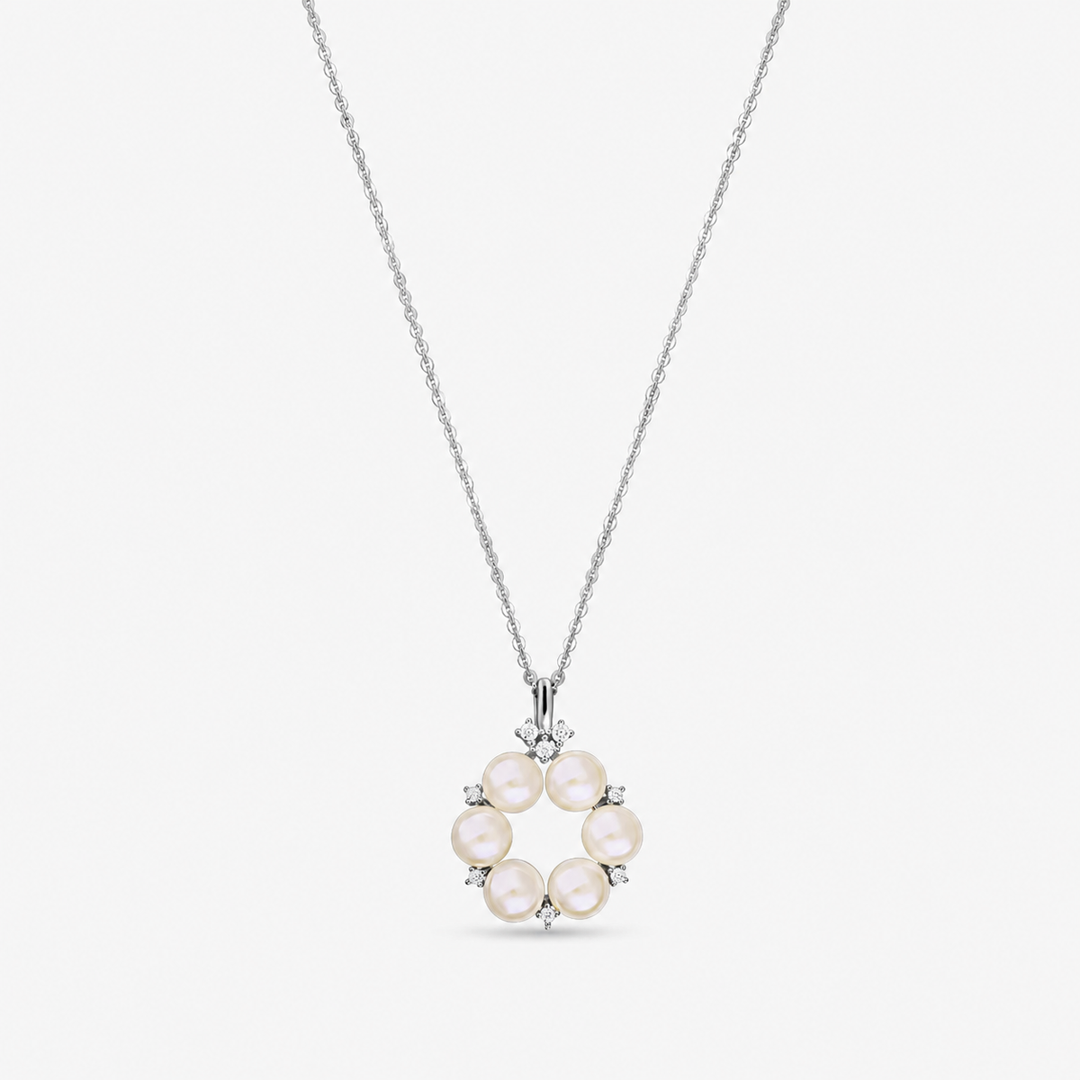 Collana in argento sterling con ciondolo circolare composto da sei perle naturali, arricchito da piccoli zirconi bianchi, mostrata su una catenina sottile su sfondo bianco.