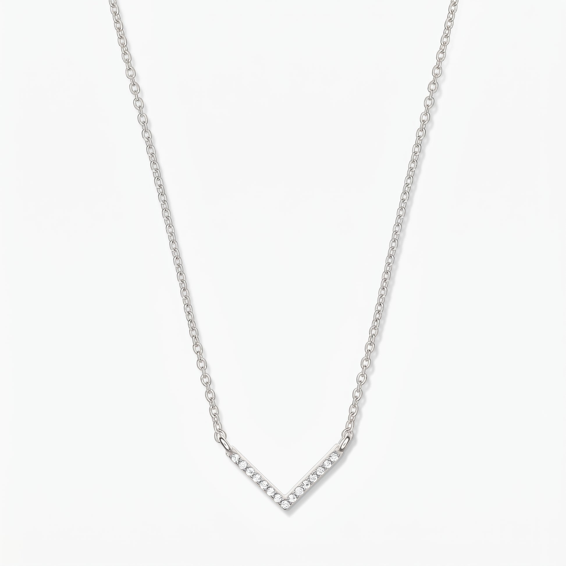 Collana a V in argento con zirconi, catena sottile e ciondolo chevron pavé su sfondo bianco.