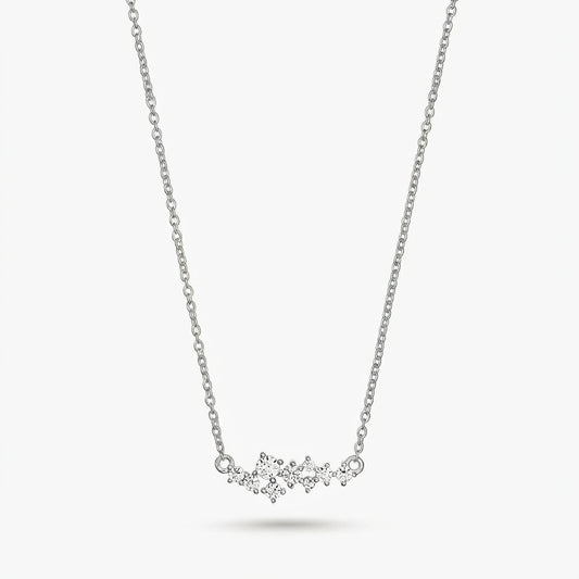 Delicata collana in argento a tema costellazione con piccole pietre trasparenti su una catenina sottile, isolata su sfondo bianco.