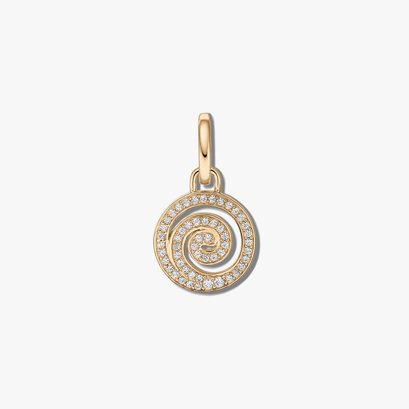 Primo piano di un pendente a spirale in argento con pietre di zirconia trasparente su sfondo bianco.