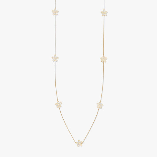 Collana d'oro con motivi floreali su sfondo bianco