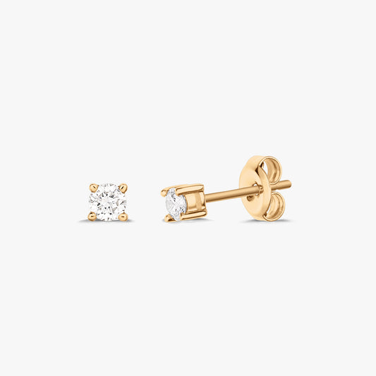 Coppia di orecchini a perno in oro con ogni orecchino caratterizzato da un diamante solitario, posizionati su uno sfondo bianco.