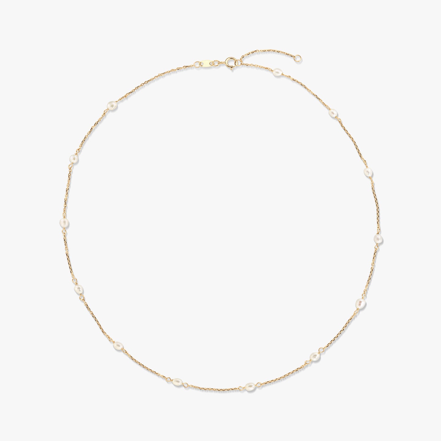 Elegante collana a stazioni in oro giallo 14K con piccole perle bianche naturali distanziate lungo una catenina sottile, isolata su sfondo bianco.