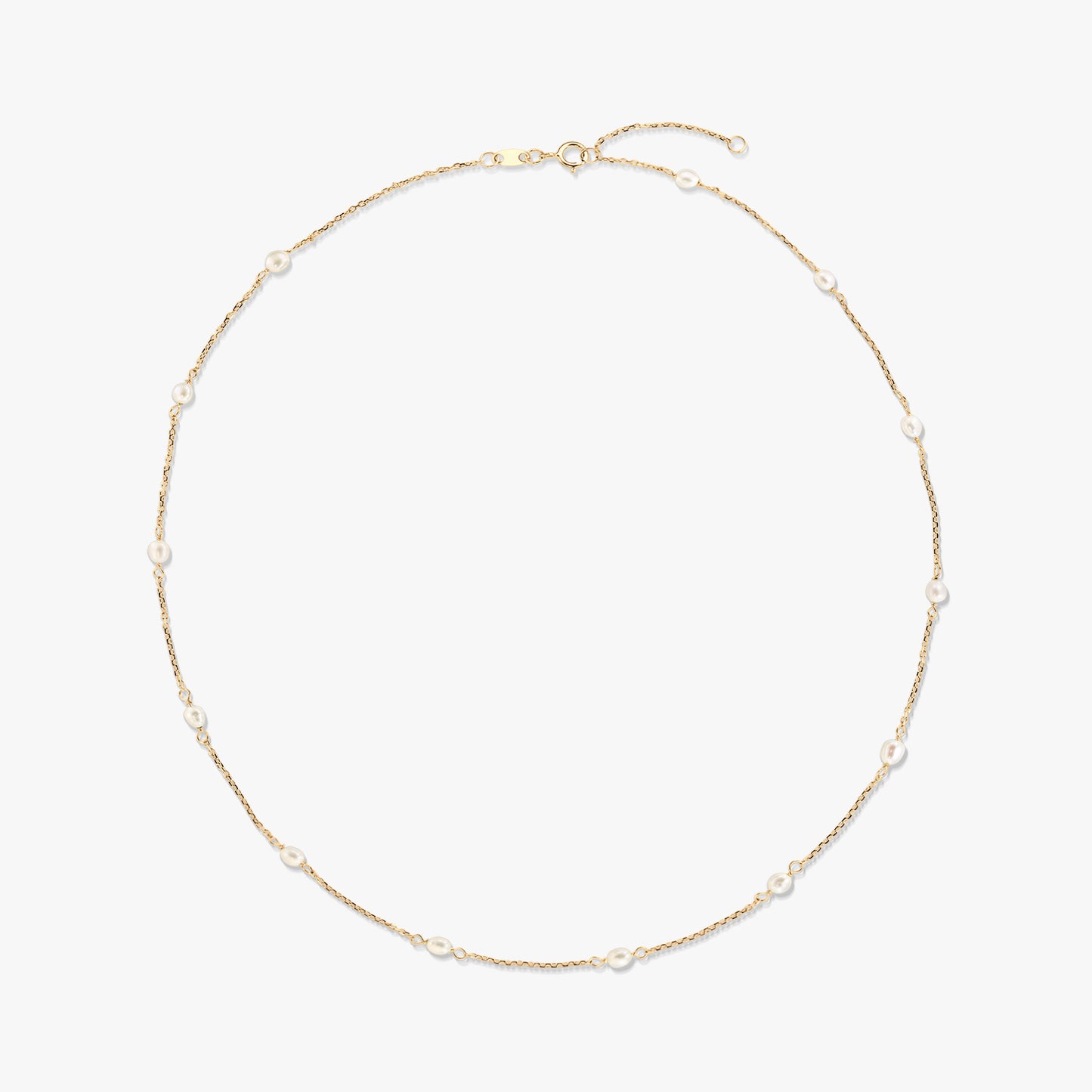 Elegante collana a stazioni in oro giallo 14K con piccole perle bianche naturali distanziate lungo una catenina sottile, isolata su sfondo bianco.
