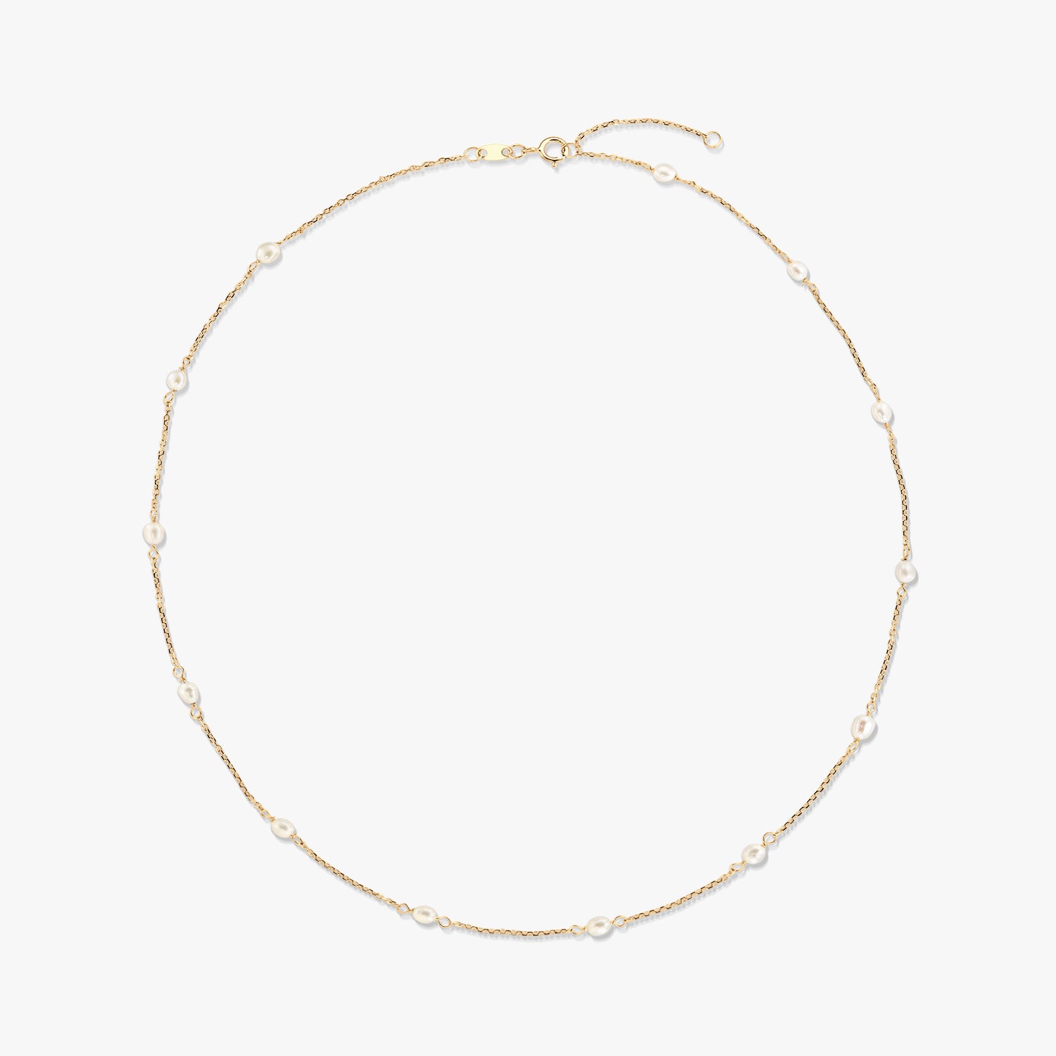 Elegante collana a stazioni in oro giallo 14K con piccole perle bianche naturali distanziate lungo una catenina sottile, isolata su sfondo bianco.
