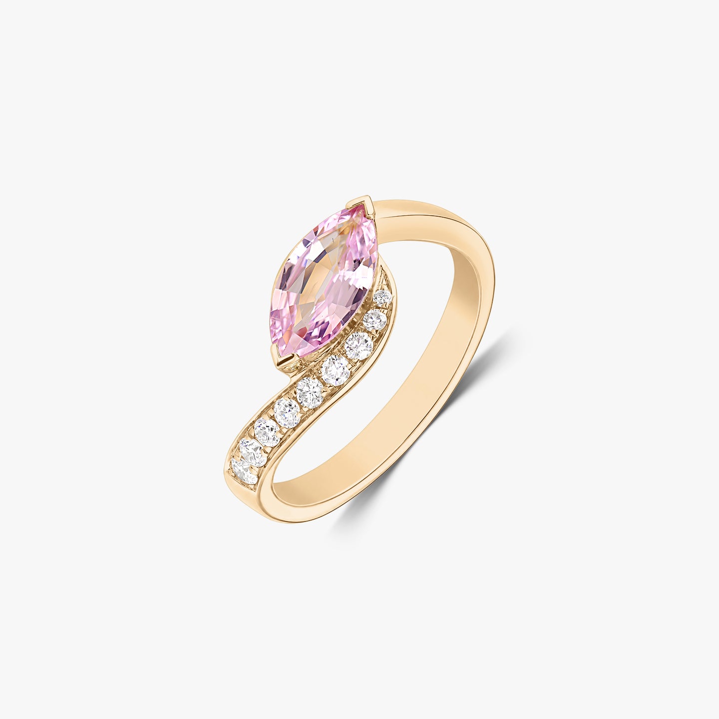 Anello bypass in oro giallo 14K con uno zaffiro rosa taglio marquise e una fila di diamanti naturali, isolato su sfondo bianco.