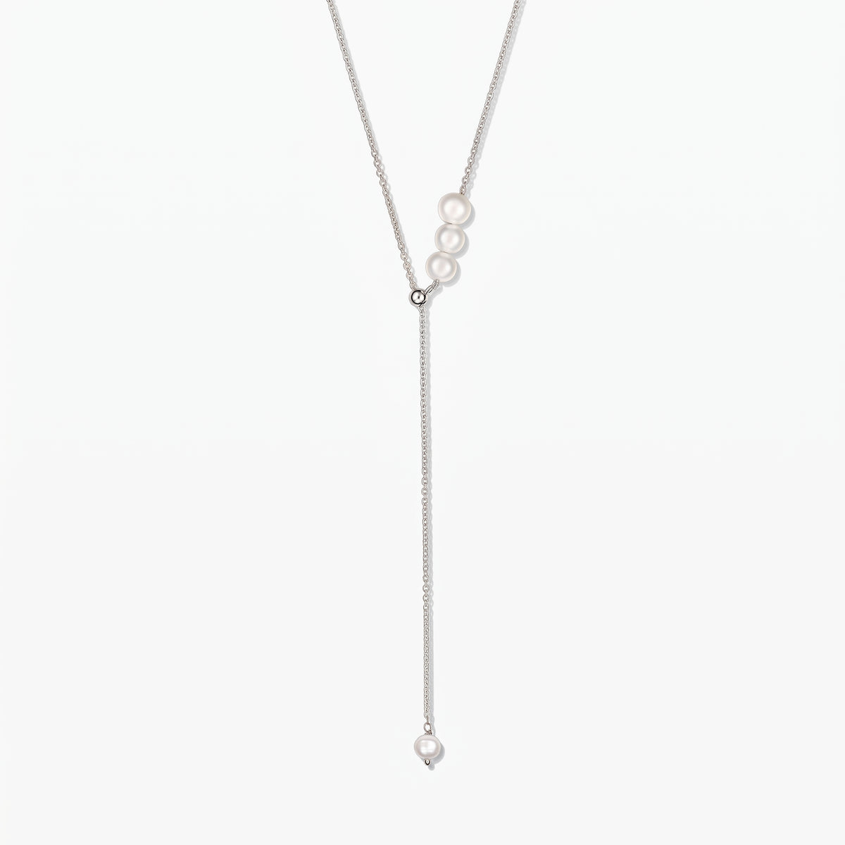 Collana lariat regolabile in argento sterling con perle coltivate bianche, centrata su sfondo bianco.