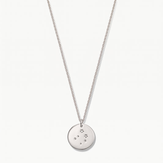 Collana in argento sterling con pendente a medaglia zodiacale Bilancia, con accenti di zaffiro bianco su una catena delicata, fotografata su sfondo bianco.