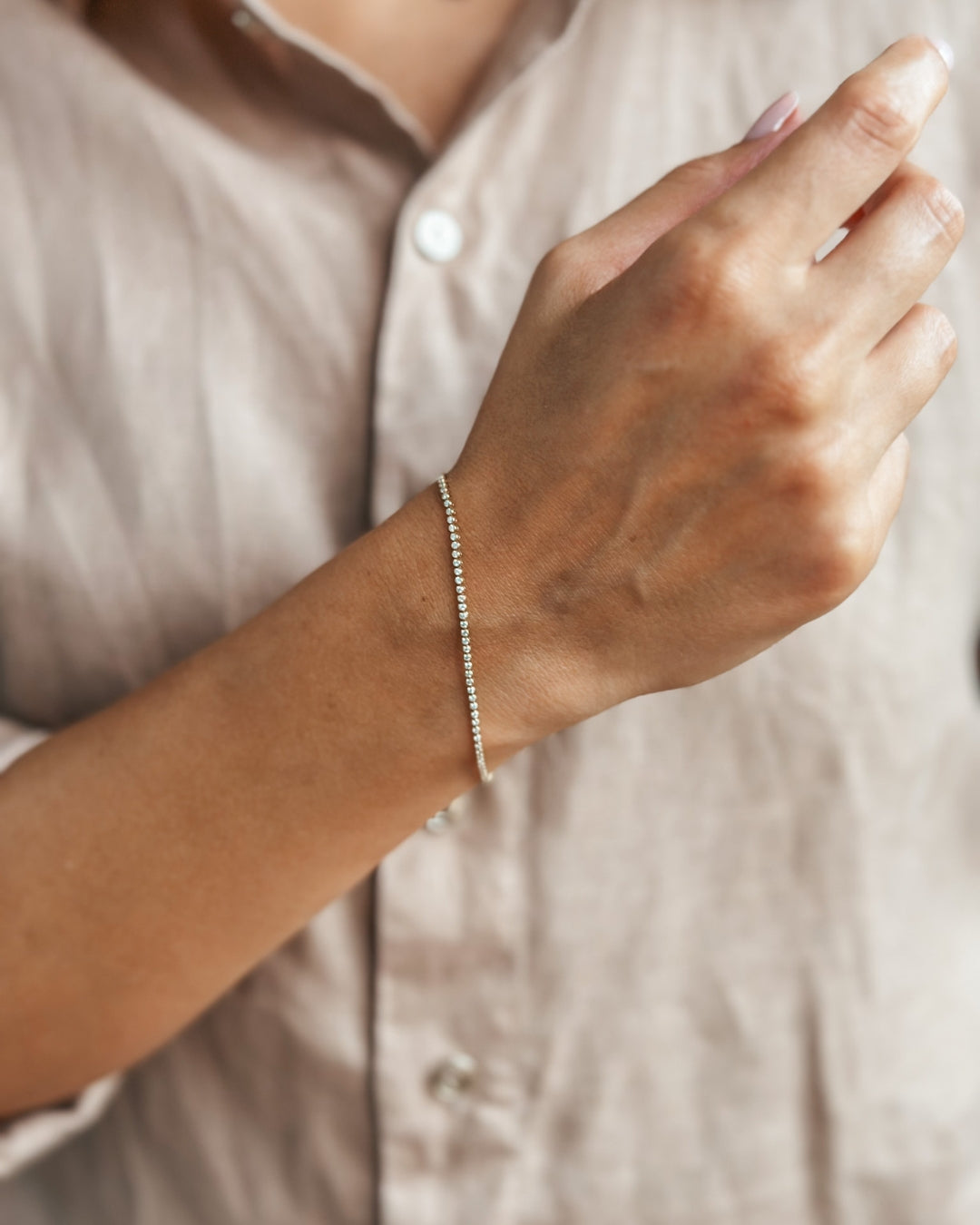 Immagine ravvicinata di una mano che indossa un braccialetto sottile ed elegante